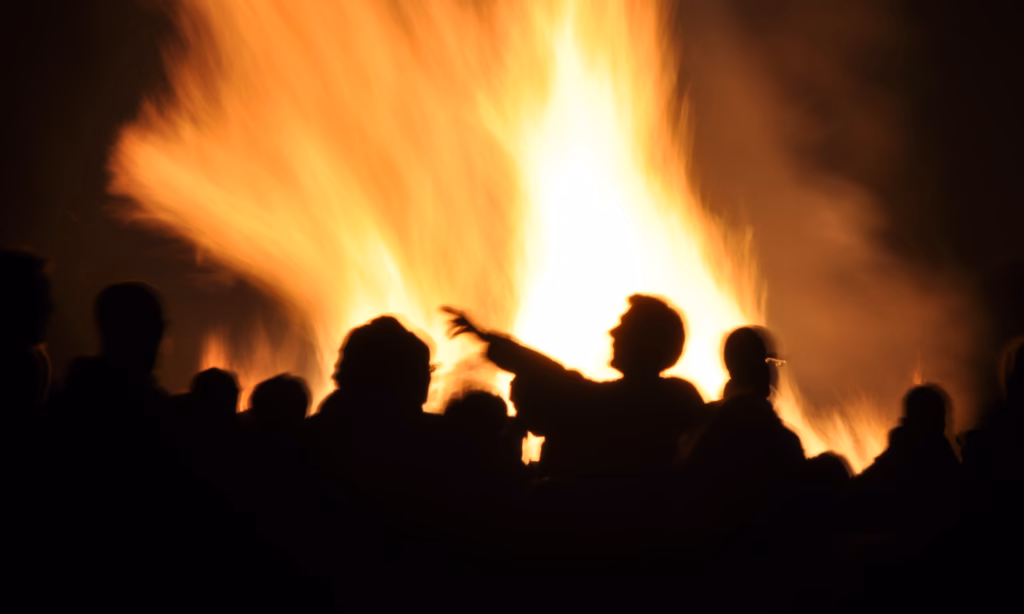 People silhouetted against a large bonfire on Bonfire Night