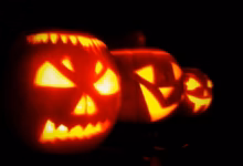 A carved Halloween jack-o'-lantern glowing in the dark